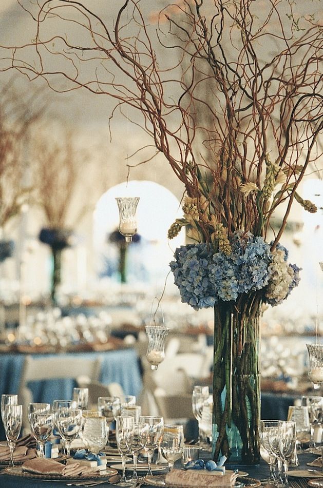 a vase filled with flowers sitting on top of a table covered in plates and glasses