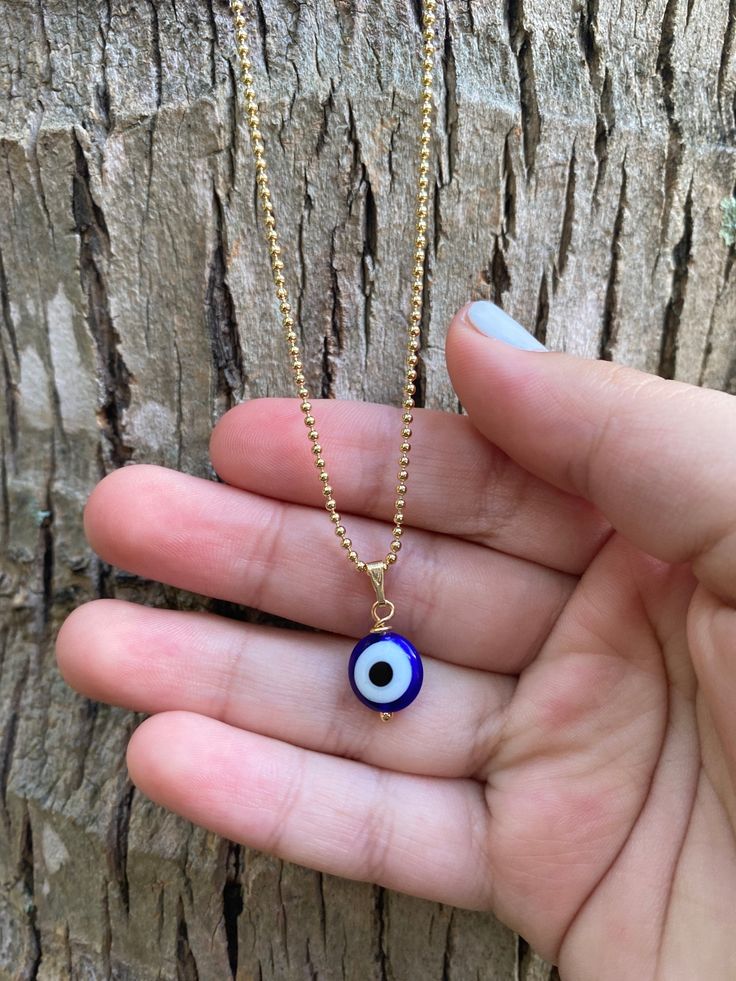 "This necklace is combination of -Handmade Blue Evil Glass bead. -18\" Gold Filled Chain . 🧿The evil eye is a curse or legend believed to be cast by a malevolent glare, usually given to a person when they are unaware. ... Talismans or amulets created to protect against the evil eye are also frequently called \"evil eyes\".🧿" Blue Beaded Chain Charm Necklace As Gift, Blue Beaded Charm Necklaces With Round Beads, Blue Beaded Round Pendant Necklace, Handmade Blue Charm Necklaces For Gifts, Handmade Blue Charm Necklace For Gift, Blue Evil Eye Beaded Necklaces, Gold Beaded Necklaces With Evil Eye For Gifts, Blue Beaded Chain Spiritual Necklace, Blue Spiritual Beaded Chain Necklace