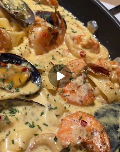 pasta with shrimp, clams and sauce in a skillet on a stove top