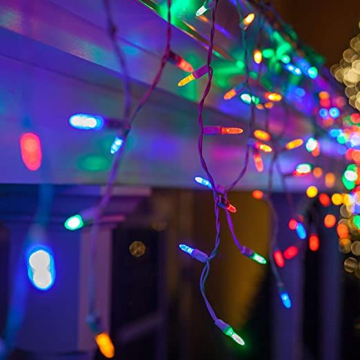 christmas lights hanging from the side of a building