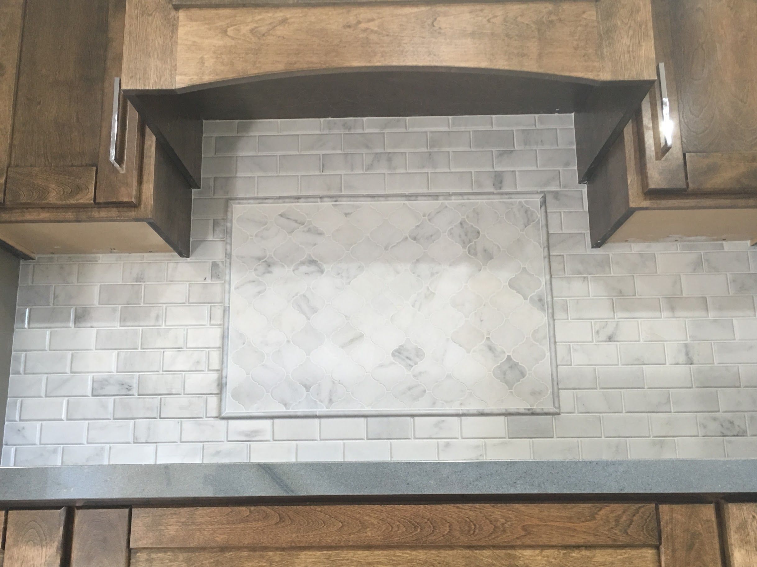 White Marble Kitchen Backsplash. 3” Arabesque Lantern inset above range (Venato Carrara Honed