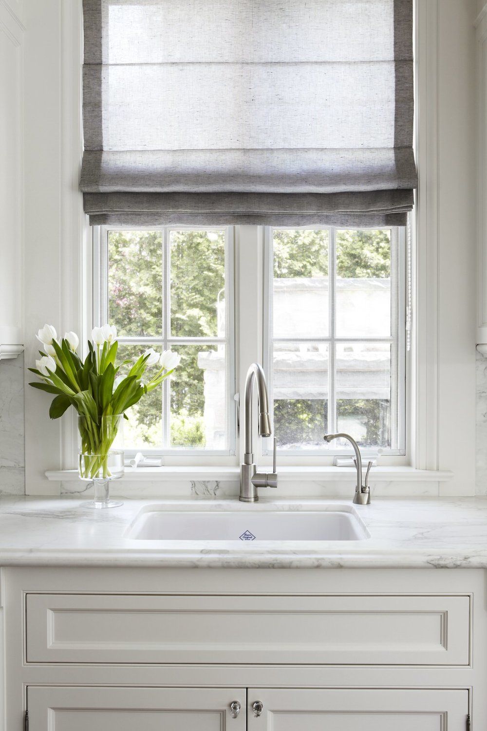 Window above kitchen sink. Modern white marble Kitchen sink