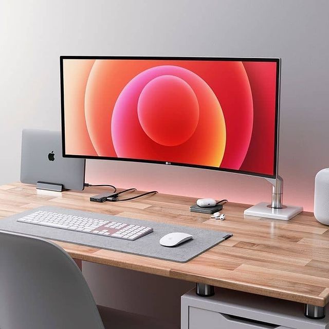 Curved display Macbook Pro desk setup.