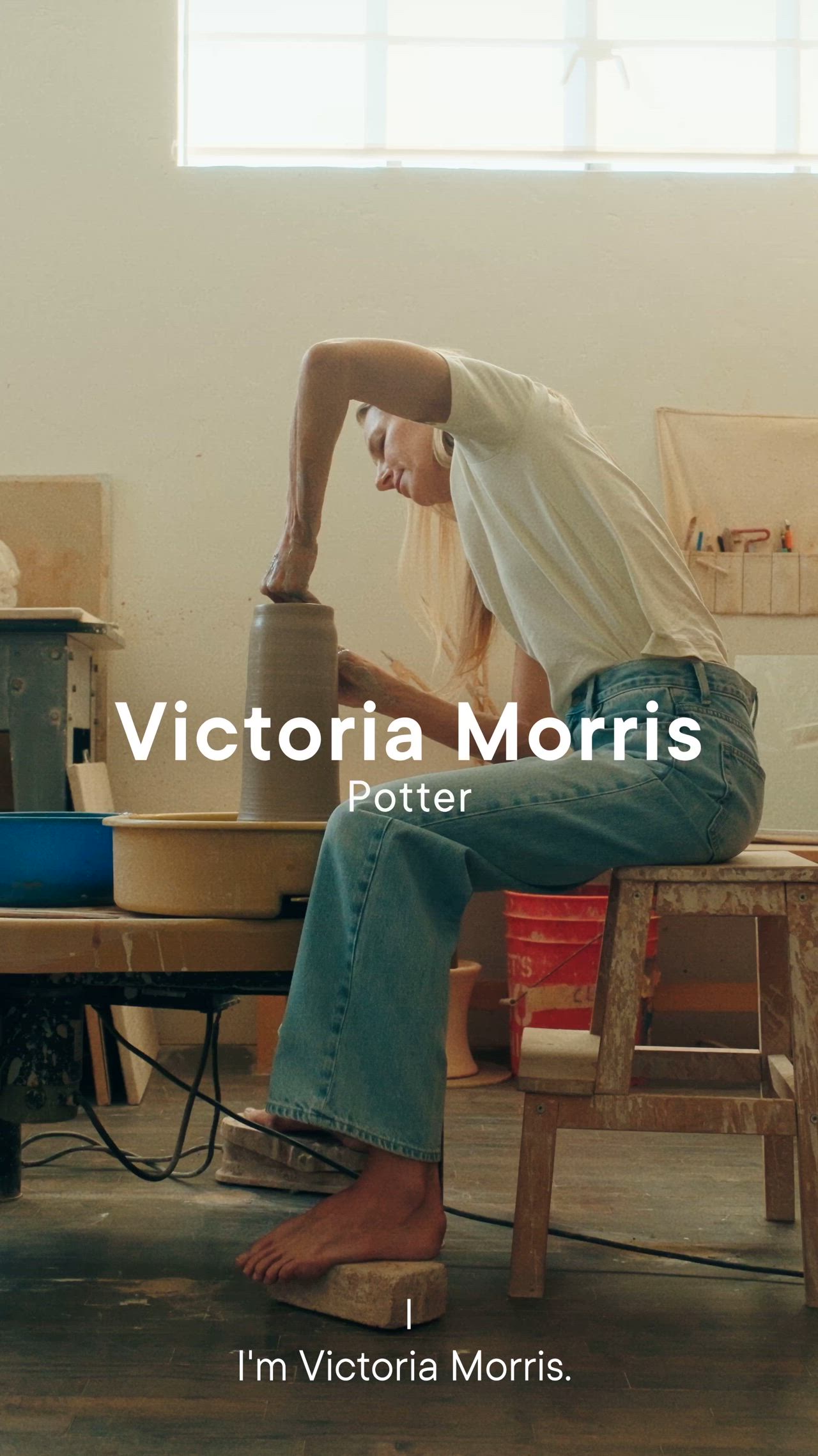 This may contain: a woman standing in front of shelves filled with pottery