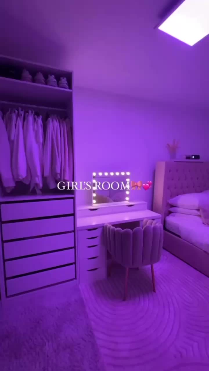 This may contain: a bedroom with purple lighting and white furniture