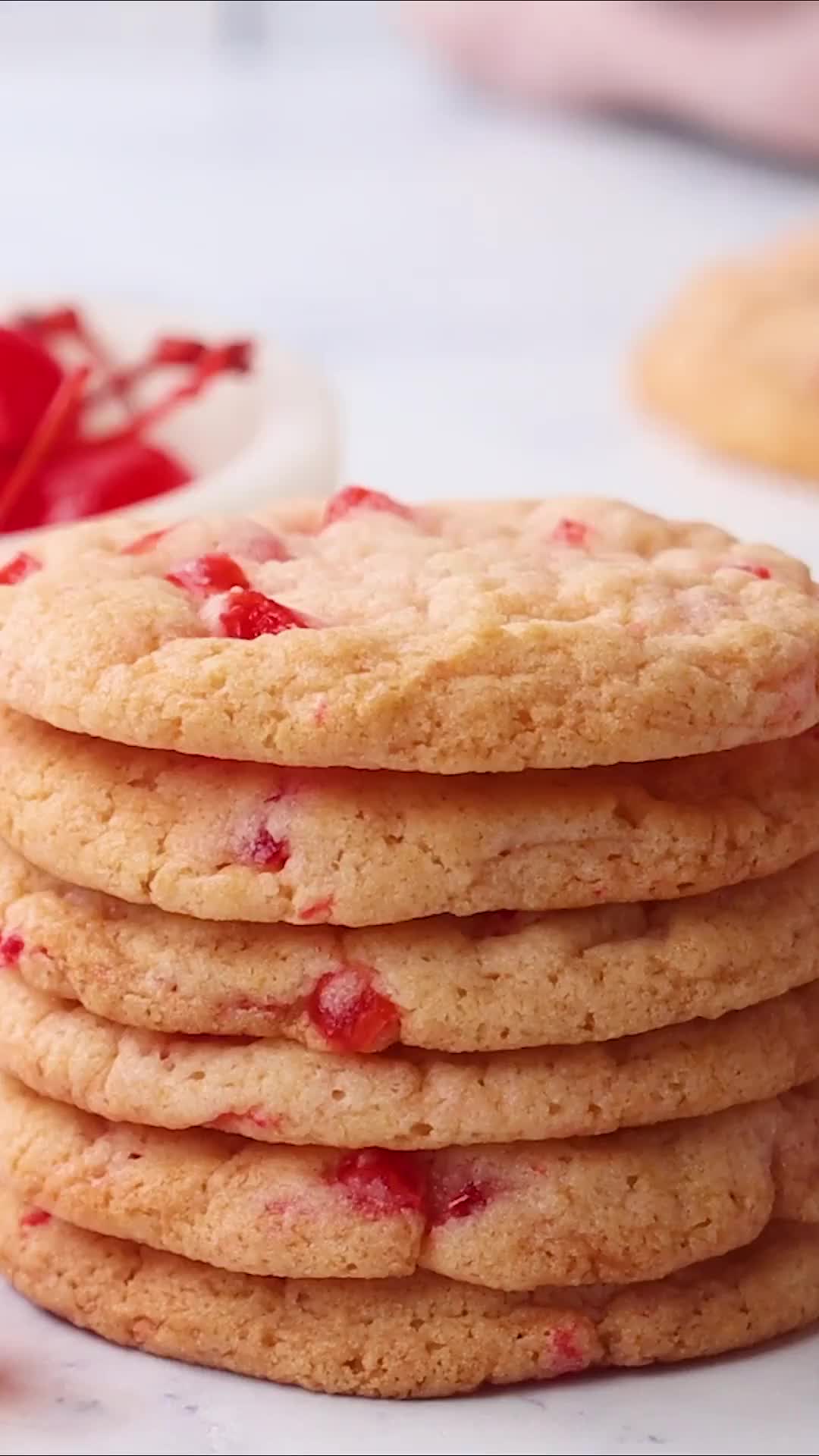 This may contain: a hand is picking up a strawberry shortbread cookie