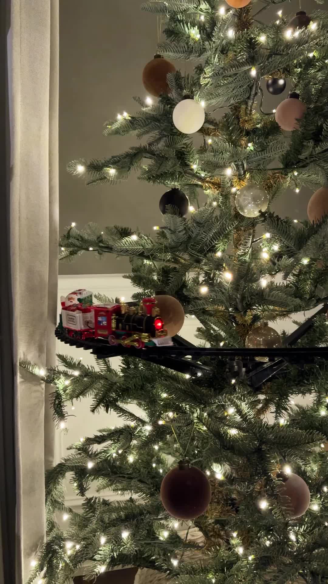 This may contain: a christmas tree with a train on it