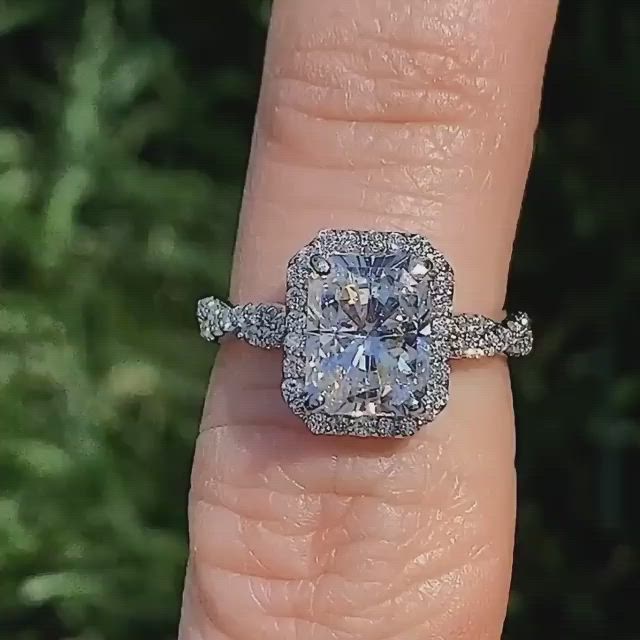 This may contain: a woman's engagement ring with an oval blue diamond surrounded by smaller round diamonds