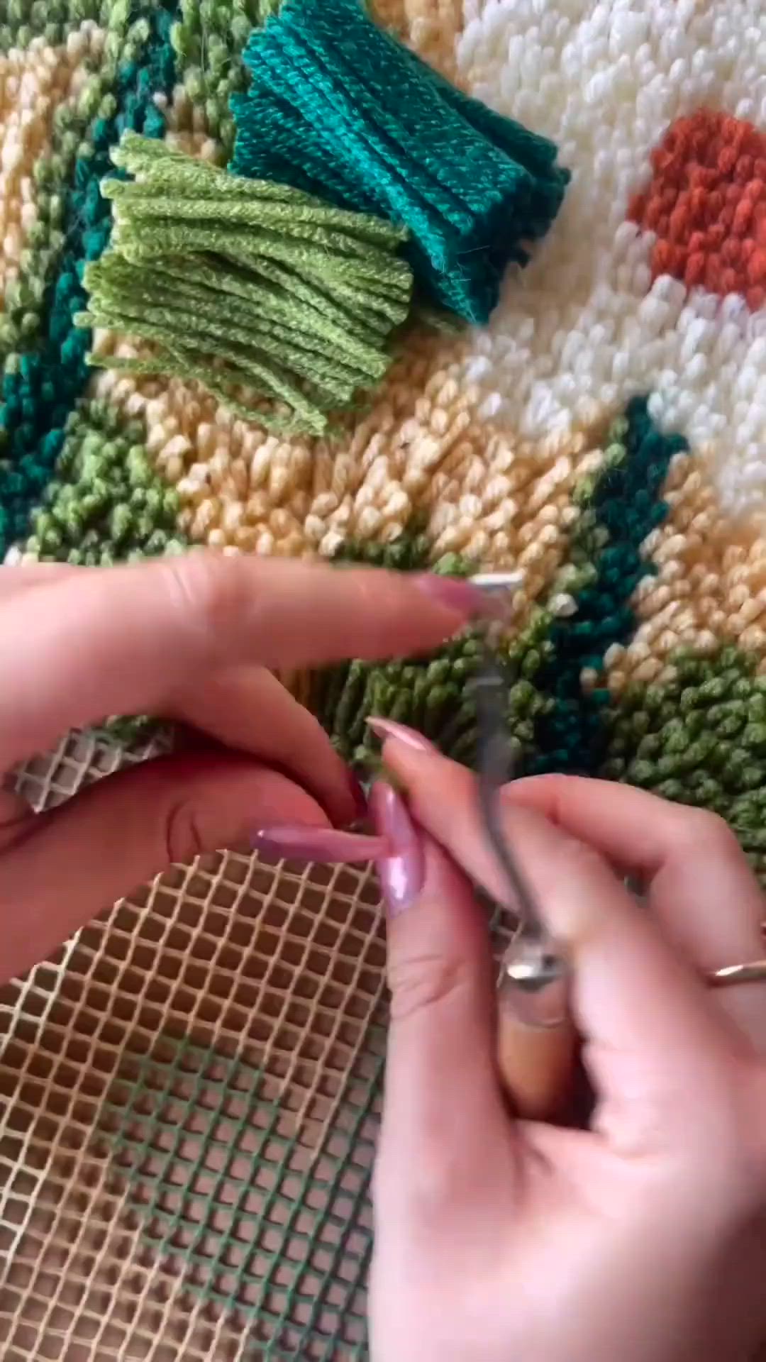 This may contain: two hands are using scissors to sew something on a piece of fabric that has been woven into it