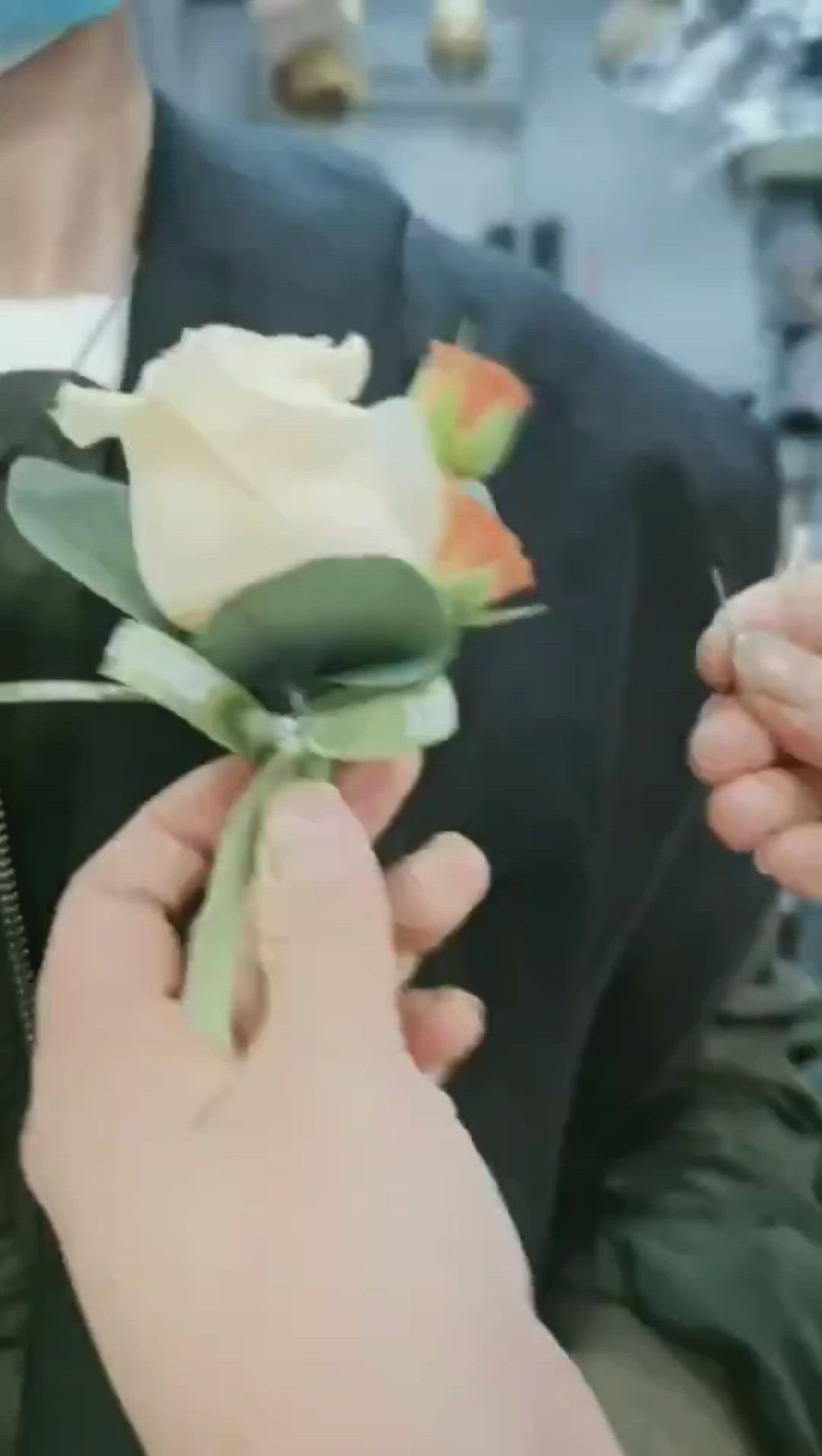 This contains: how to wear a flower boutonniere