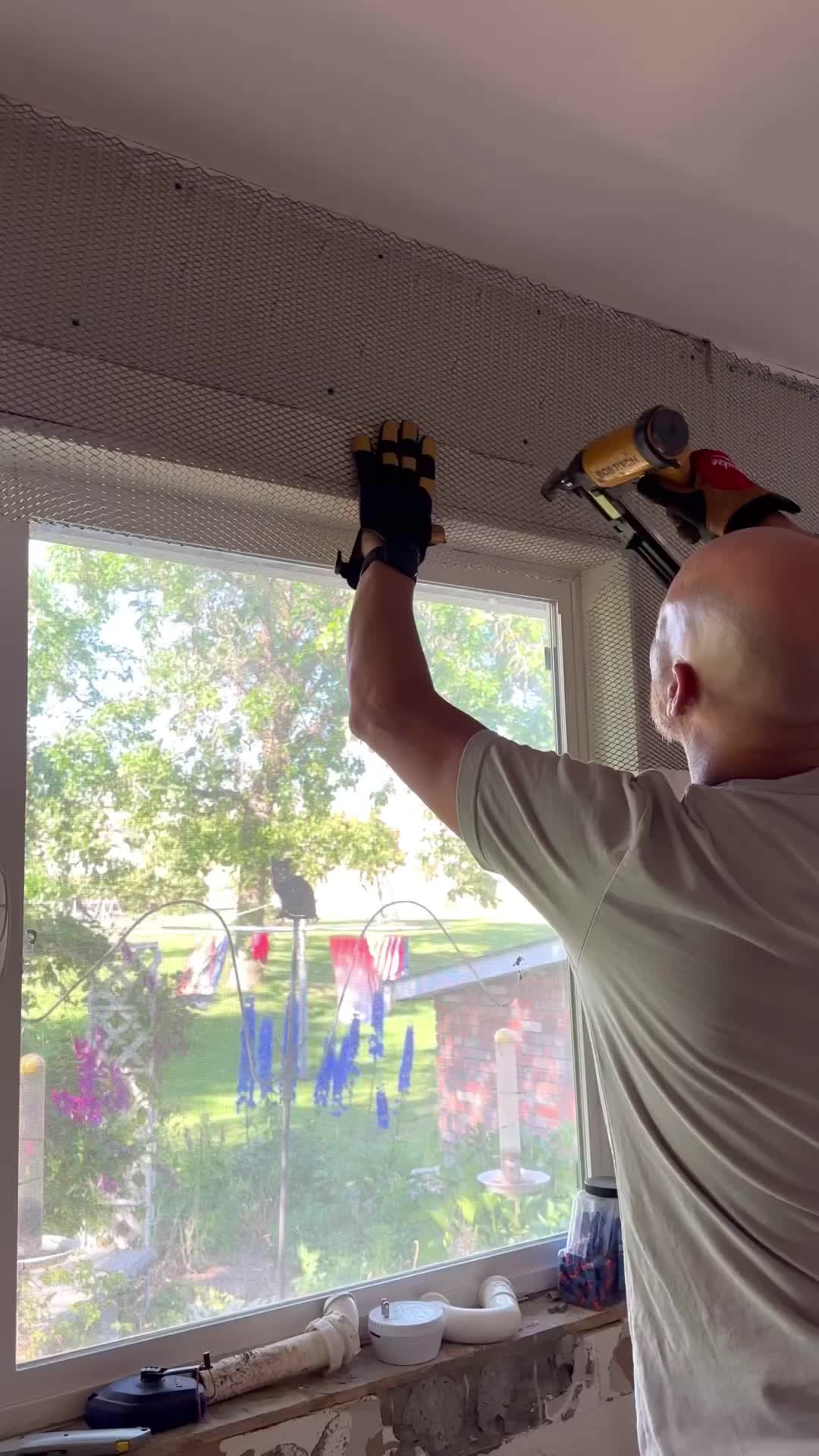 This may contain: an older man is painting the ceiling in his house with paint rollers and gloves