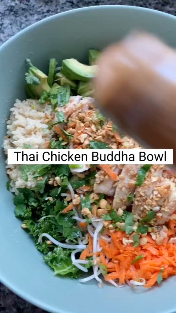 This may contain: a bowl filled with different types of veggies next to a person's hand and the words thai chicken buddha bowl