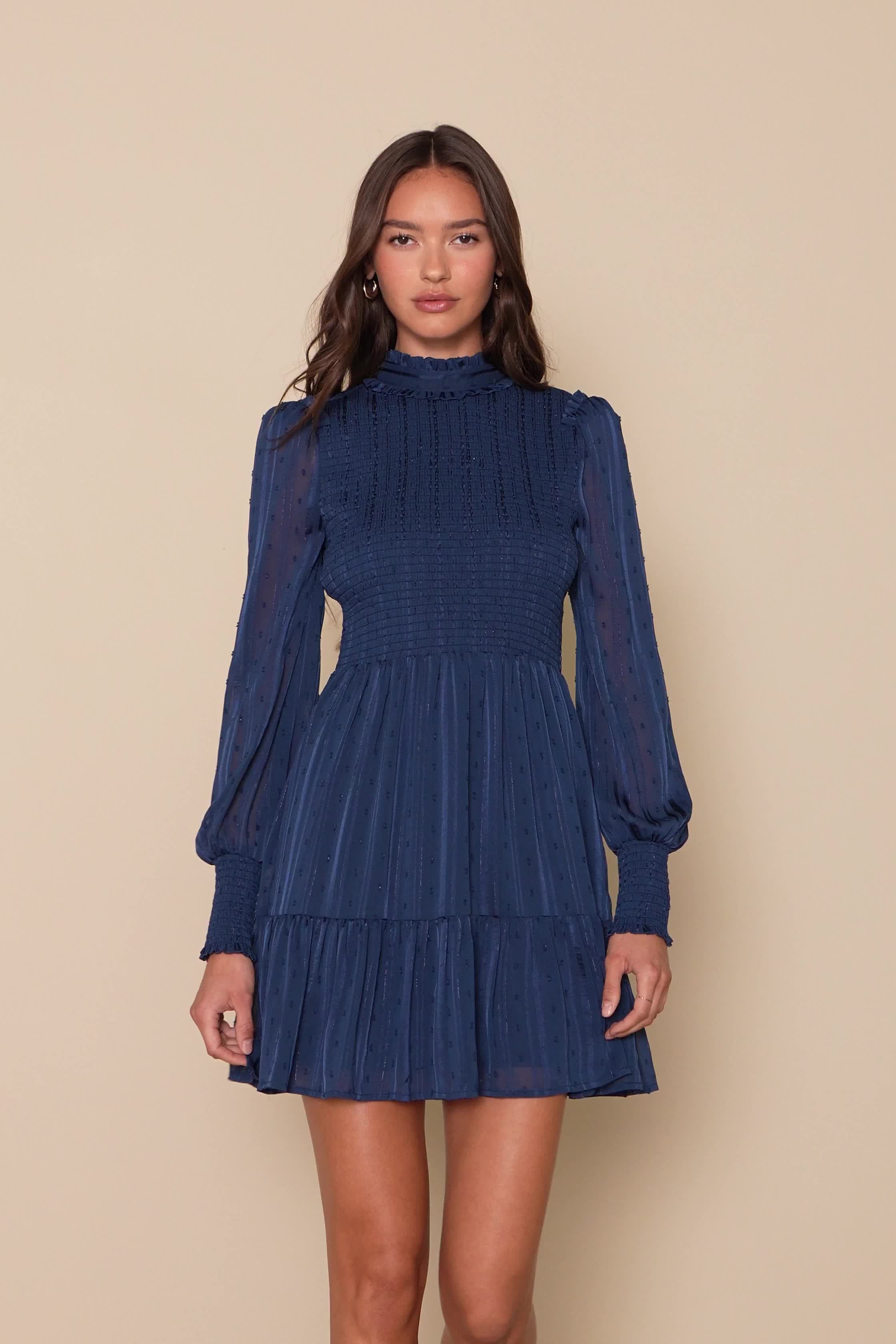 The Lulus Heartful Romance Navy Striped Smocked Long Sleeve Mini Dress has our hearts forever and always! Airy woven chiffon (with textured dots, metallic lurex, and tonal stripes throughout) shapes a ruffle-trimmed mock neckline, a smocked bodice, and long sheer sleeves with ruffles at the shoulders and smocking at the cuffs. Flowy mini skirt has a tiered hem. Back keyhole secures with a button closure. Fit: This garment fits true to size. Length: Mid-thigh. Size medium measures 35" from should