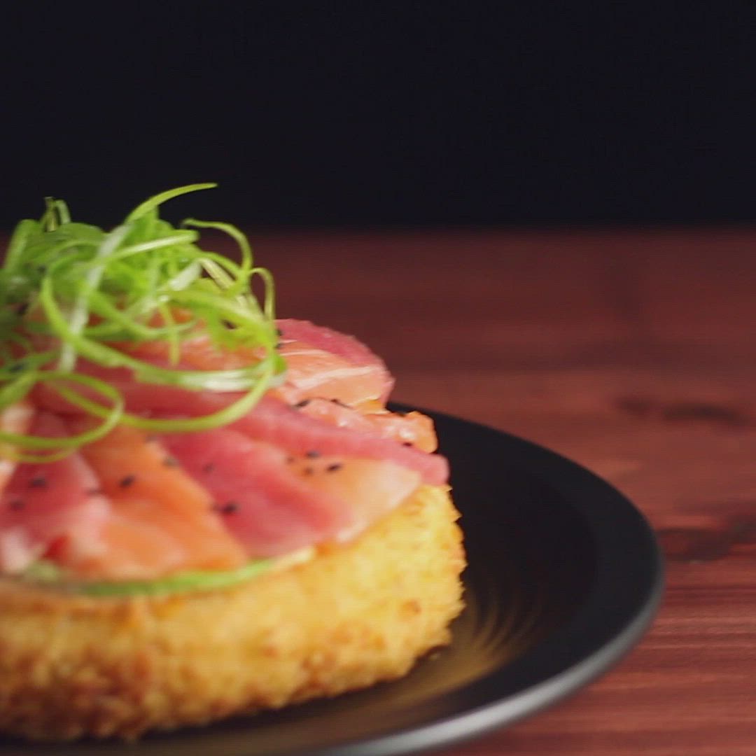 This may contain: a black plate topped with food on top of a wooden table