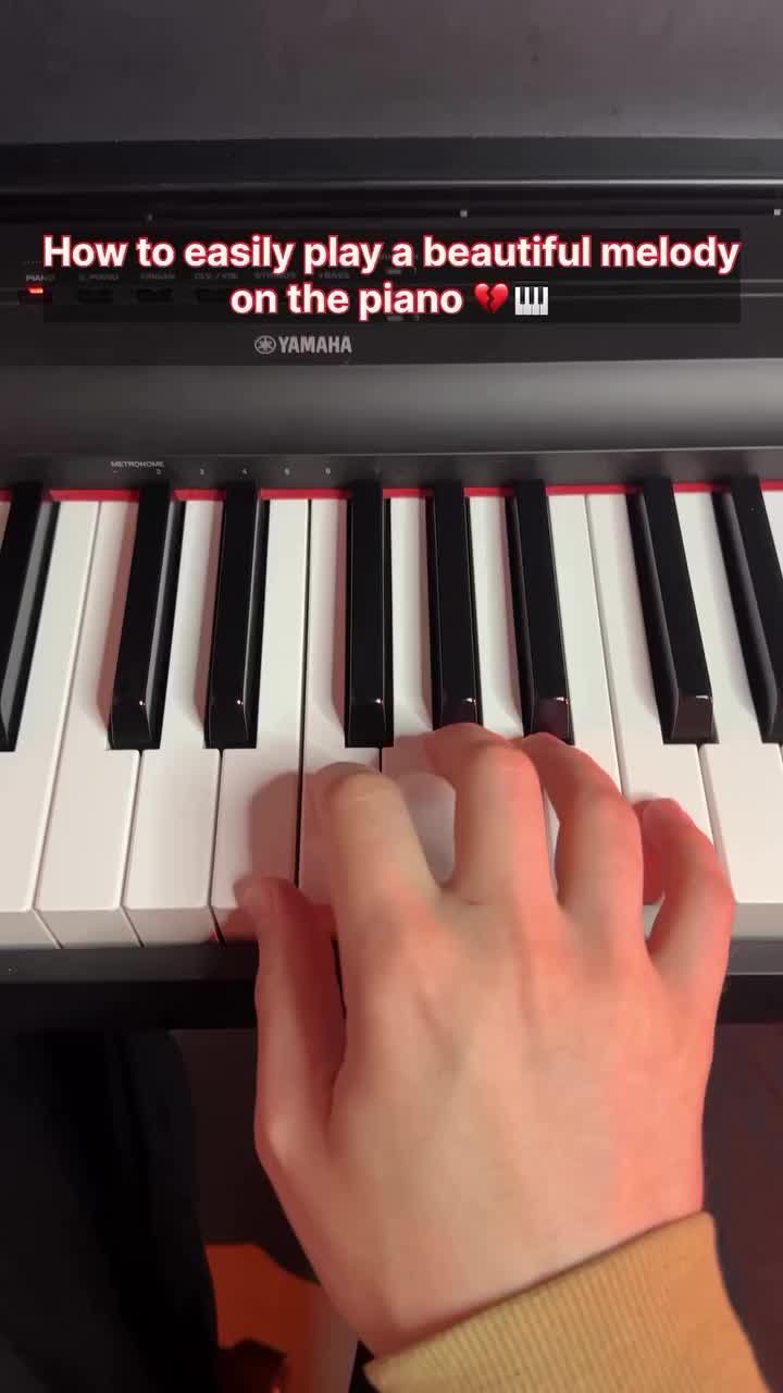 This may contain: someone is playing the piano with their hand on it's keyboard, which reads how to easily play a beautiful melody on the piano