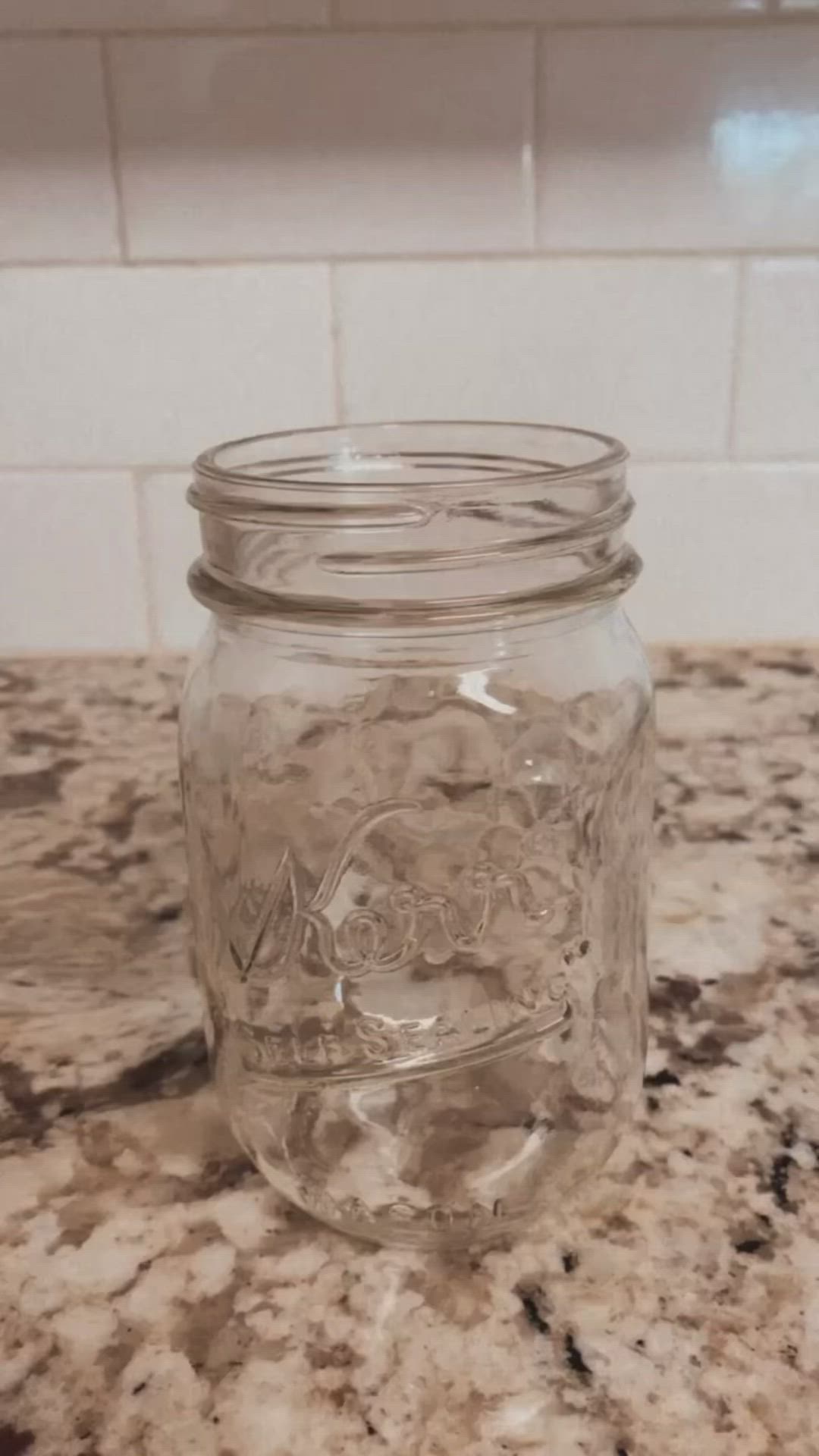 This may contain: a glass jar sitting on top of a counter