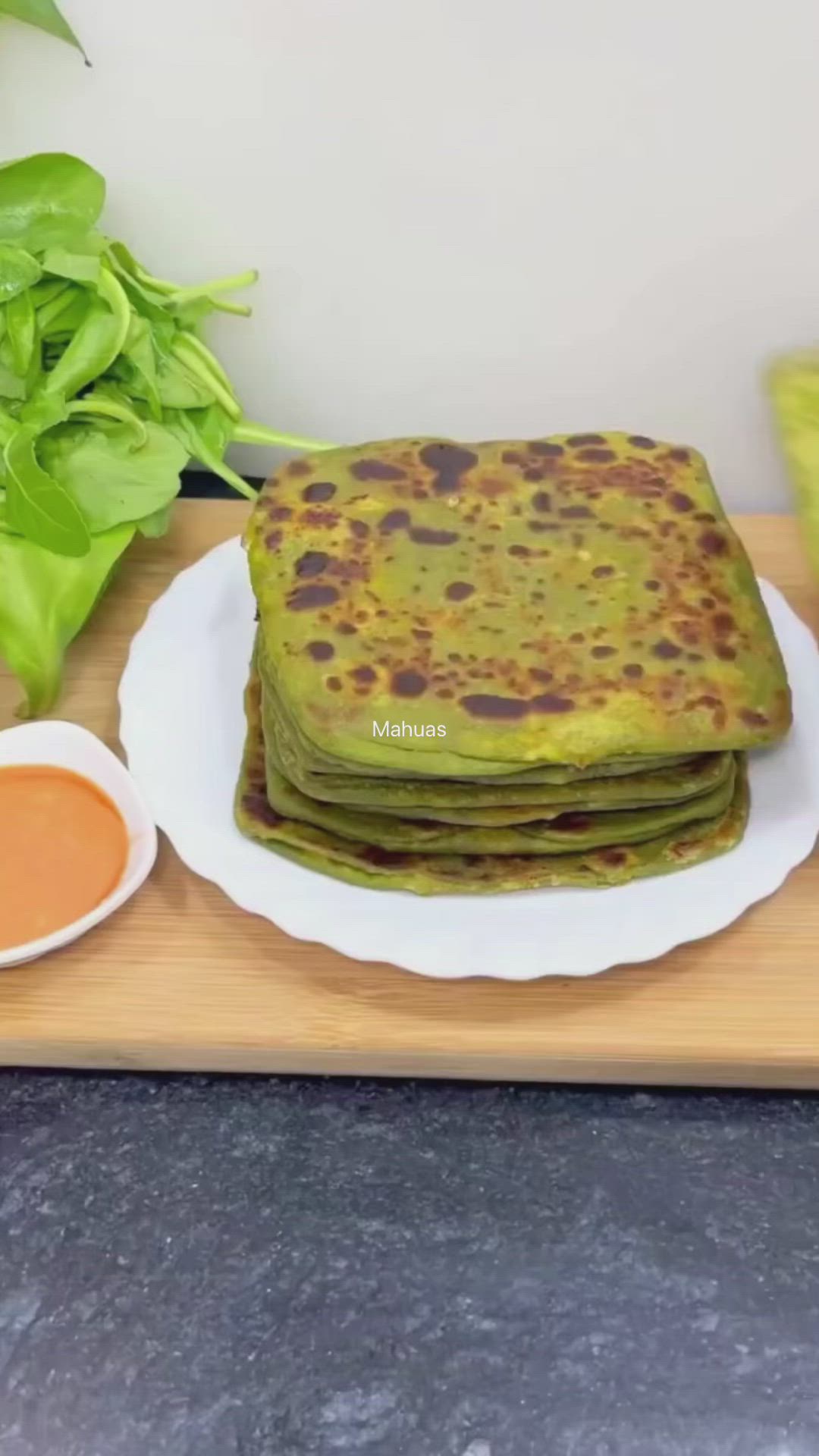 This may contain: stack of pancakes on plate next to bowl of dipping sauce and lettuce leaves