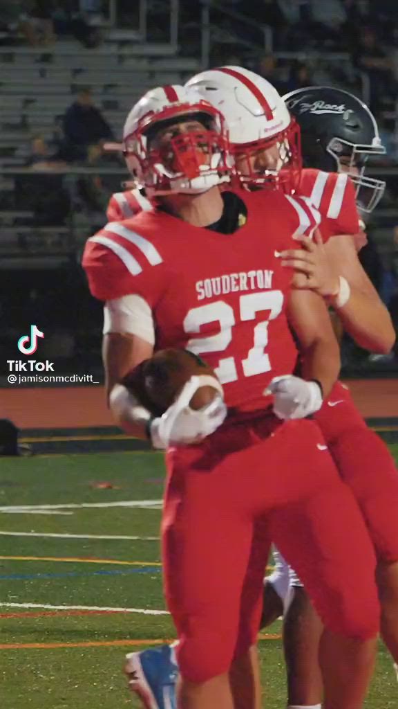 This may contain: two football players are hugging each other on the field