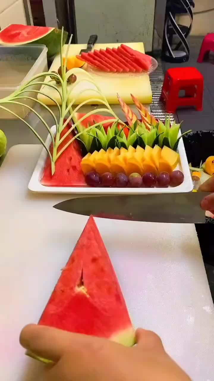 This may contain: a person cutting up slices of watermelon on top of a white plate with fruit