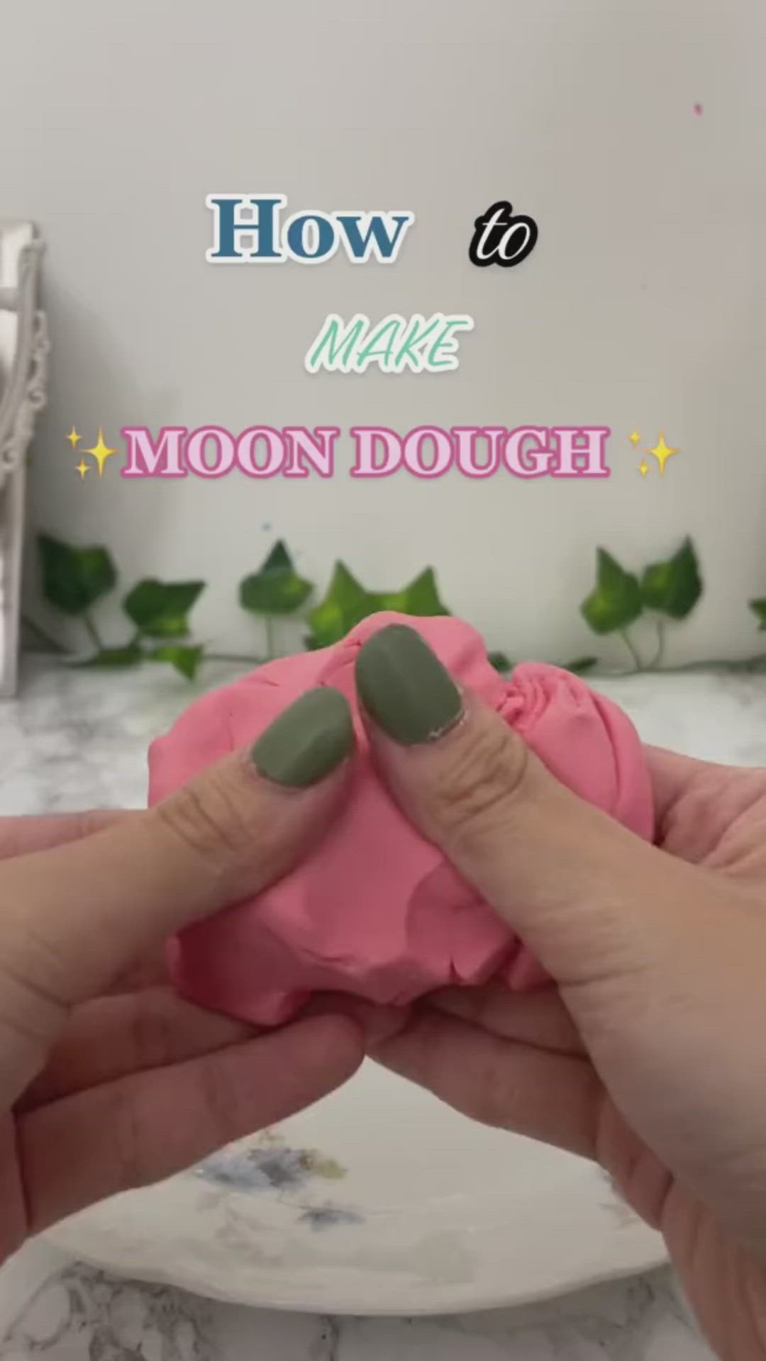 This may contain: two hands holding pink dough with green tips and text overlay reading how to make moon dough