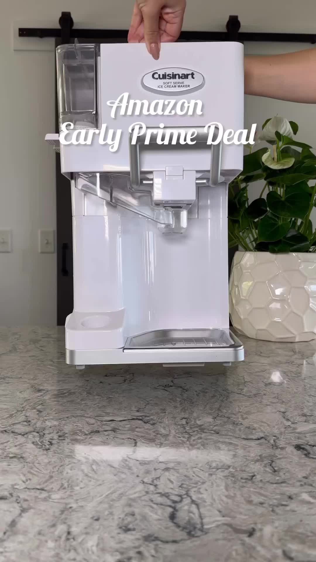 This may contain: someone holding an amazon early prime deal in front of a coffee maker on a marble countertop