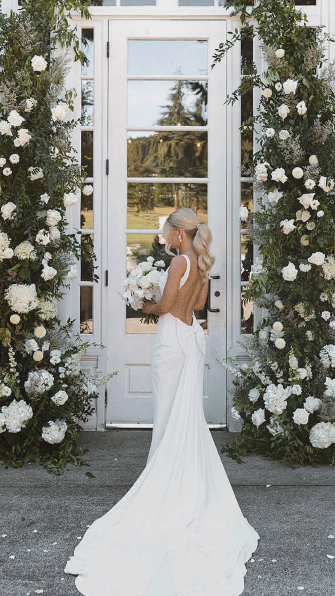 This contains: low back wedding dress, bow detail, wedding ponytail, open back wedding gown