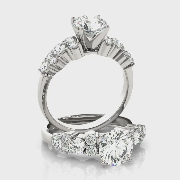 This may contain: three stone diamond engagement ring with side stones on the band and an oval brilliant setting in white gold