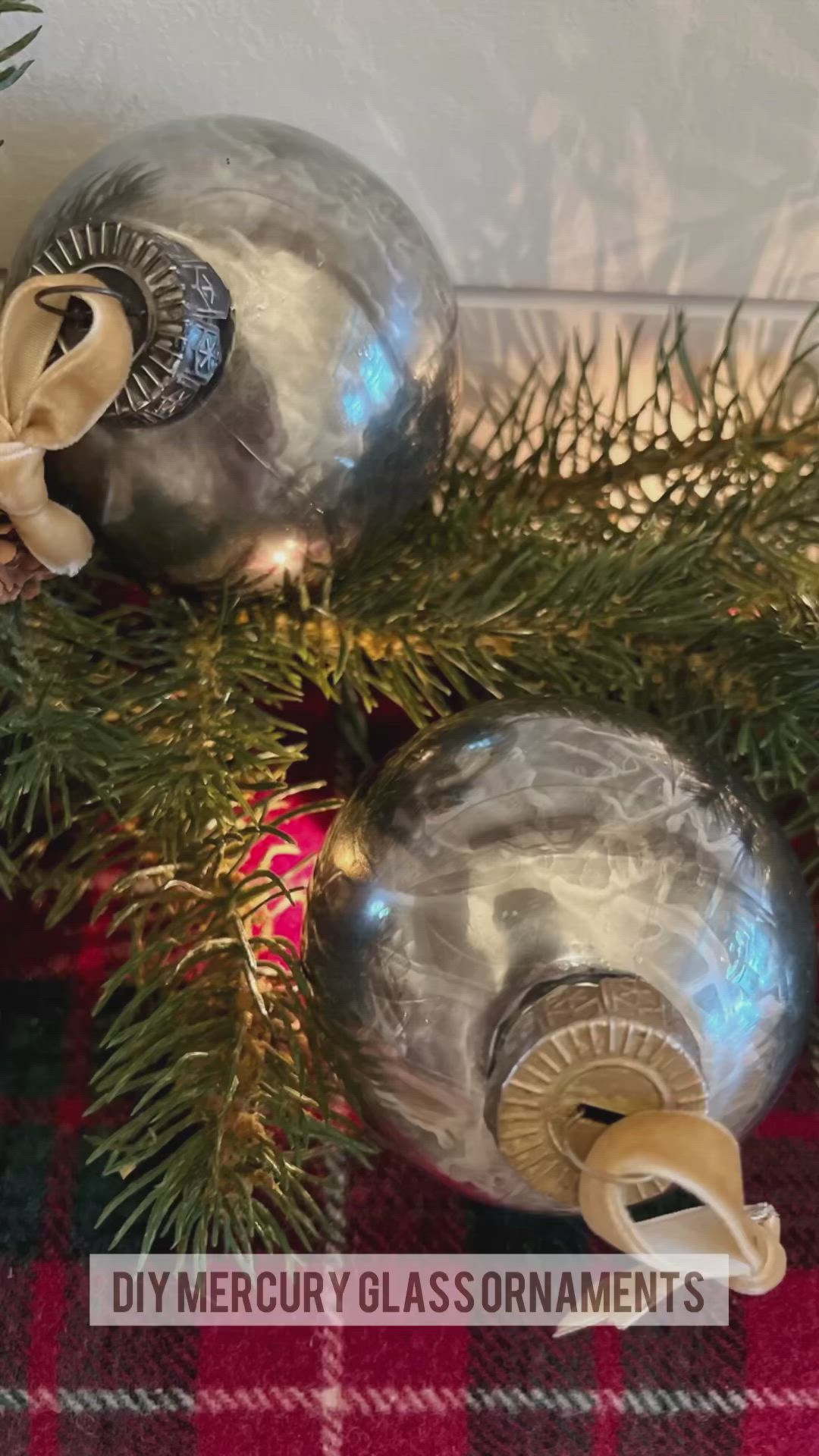 This may contain: two ornaments are sitting next to each other on a christmas table cloth with pine branches