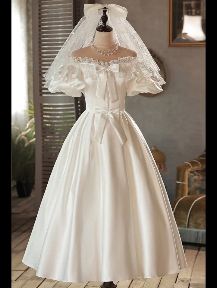 This contains: Retro Tea Length Satin Cute Off Shoulder Wedding Dress with Bows