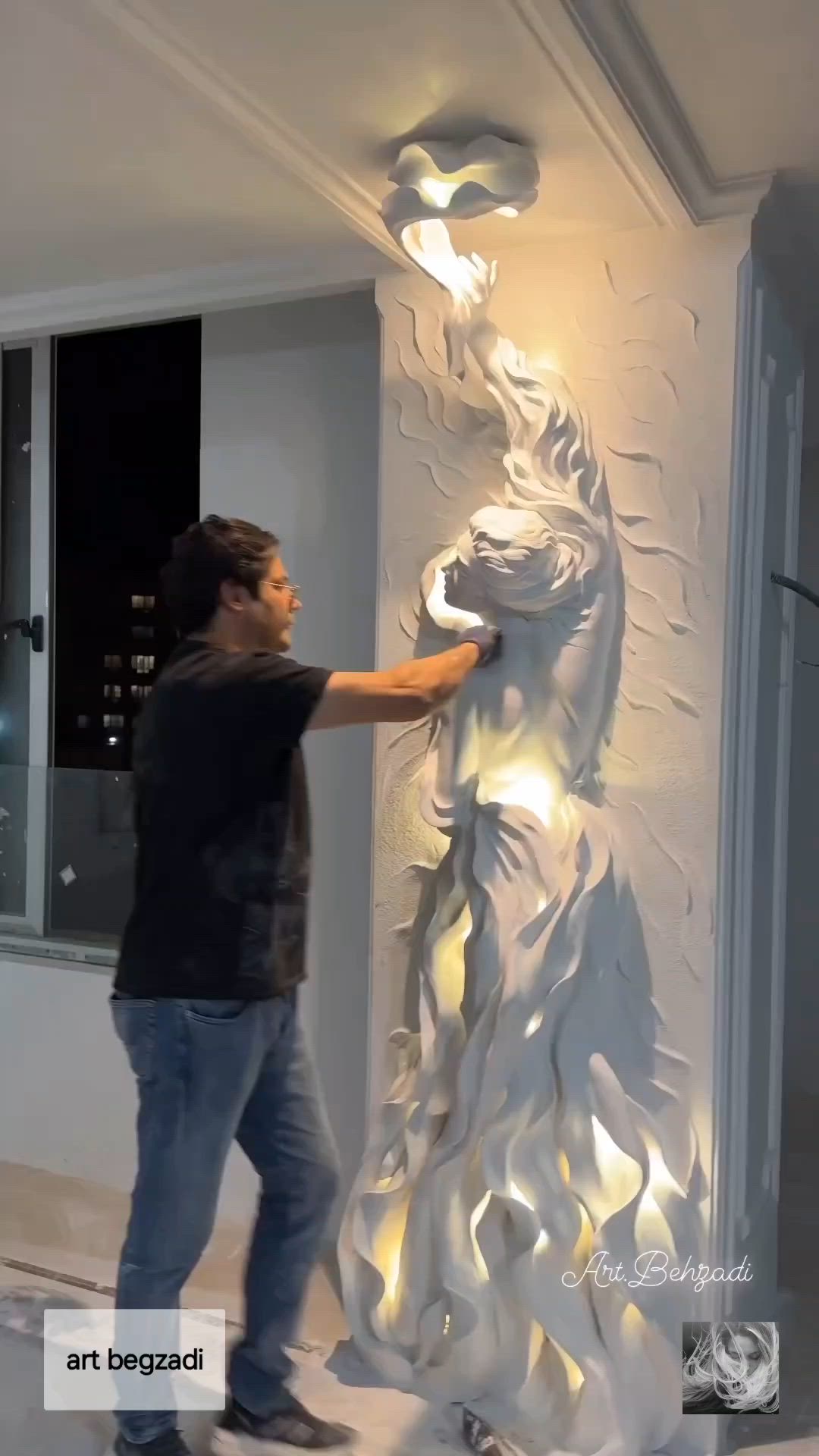 This may contain: a man standing next to a white sculpture