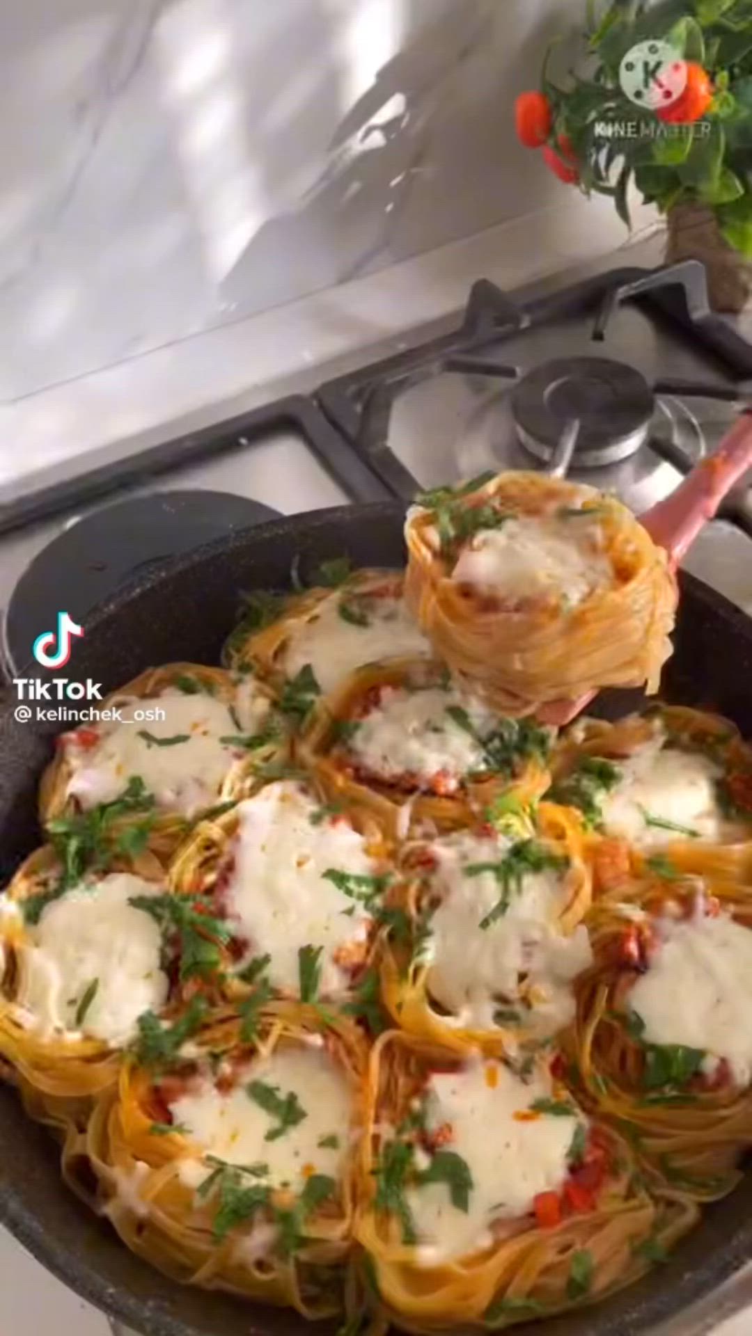 This may contain: a pan filled with pasta and sauce on top of a stove