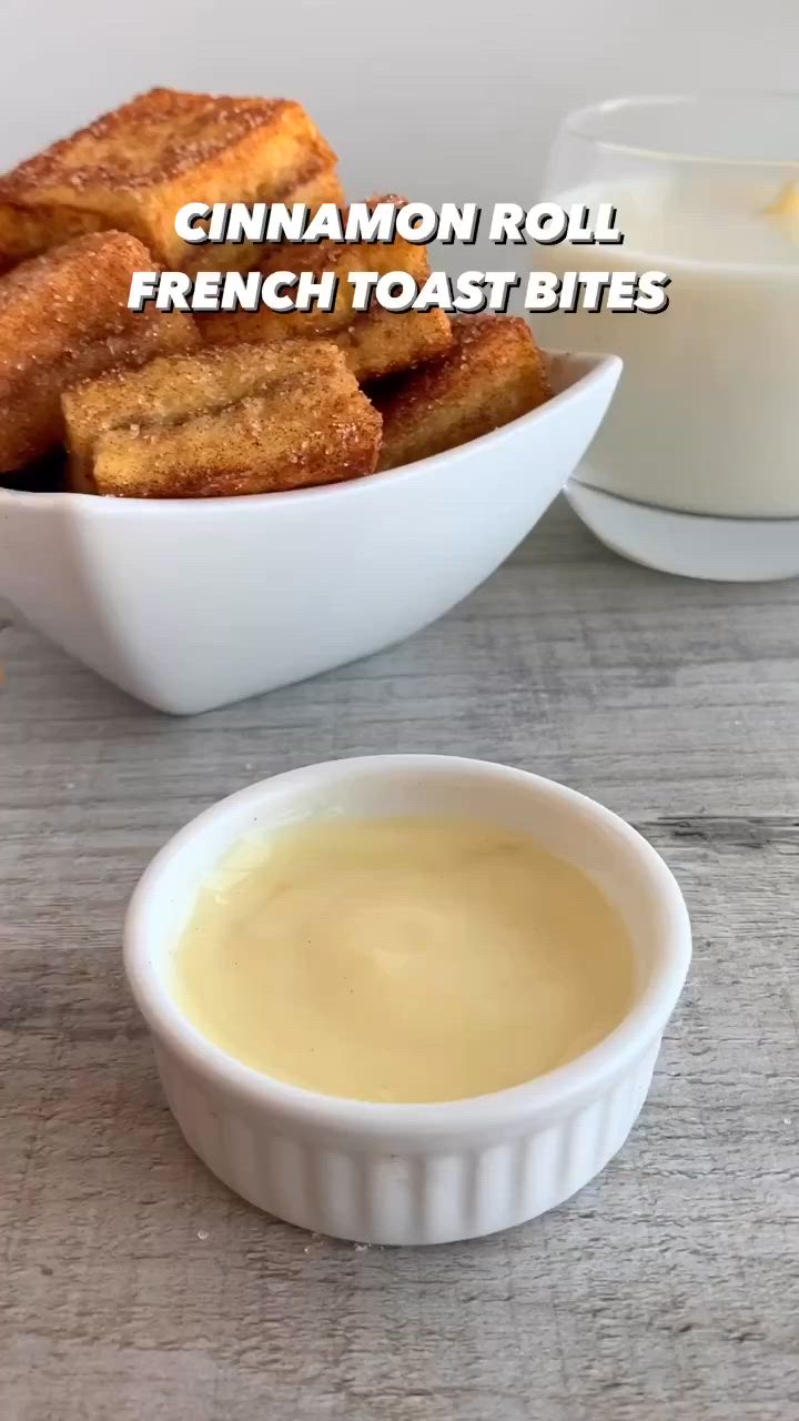 This may contain: cinnamon roll french toast bites in a white bowl