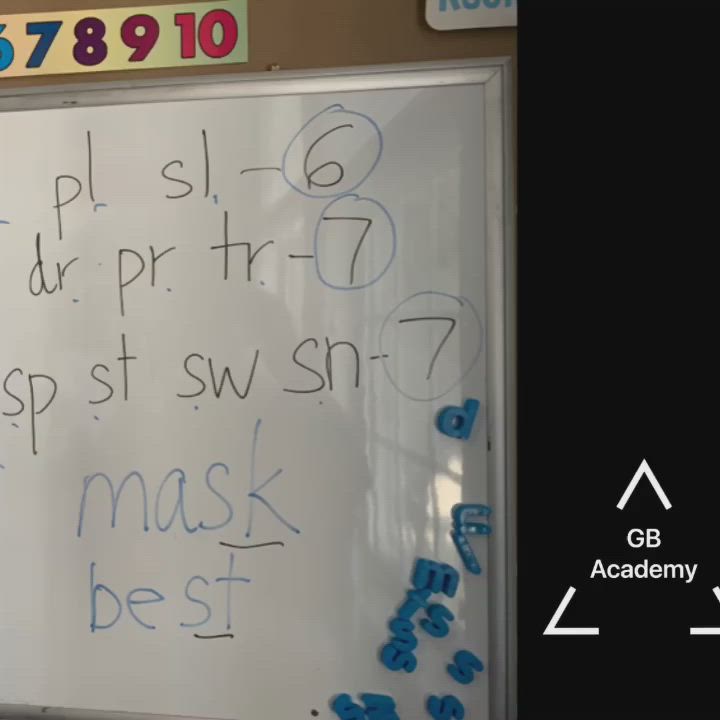 This may contain: a young boy writing on a white board