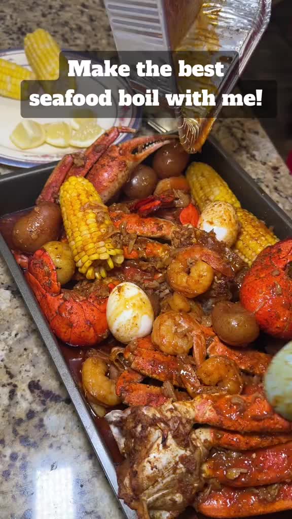 This may contain: lobsters, corn on the cob and potatoes in a pan with text that reads make the best seafood boil with me