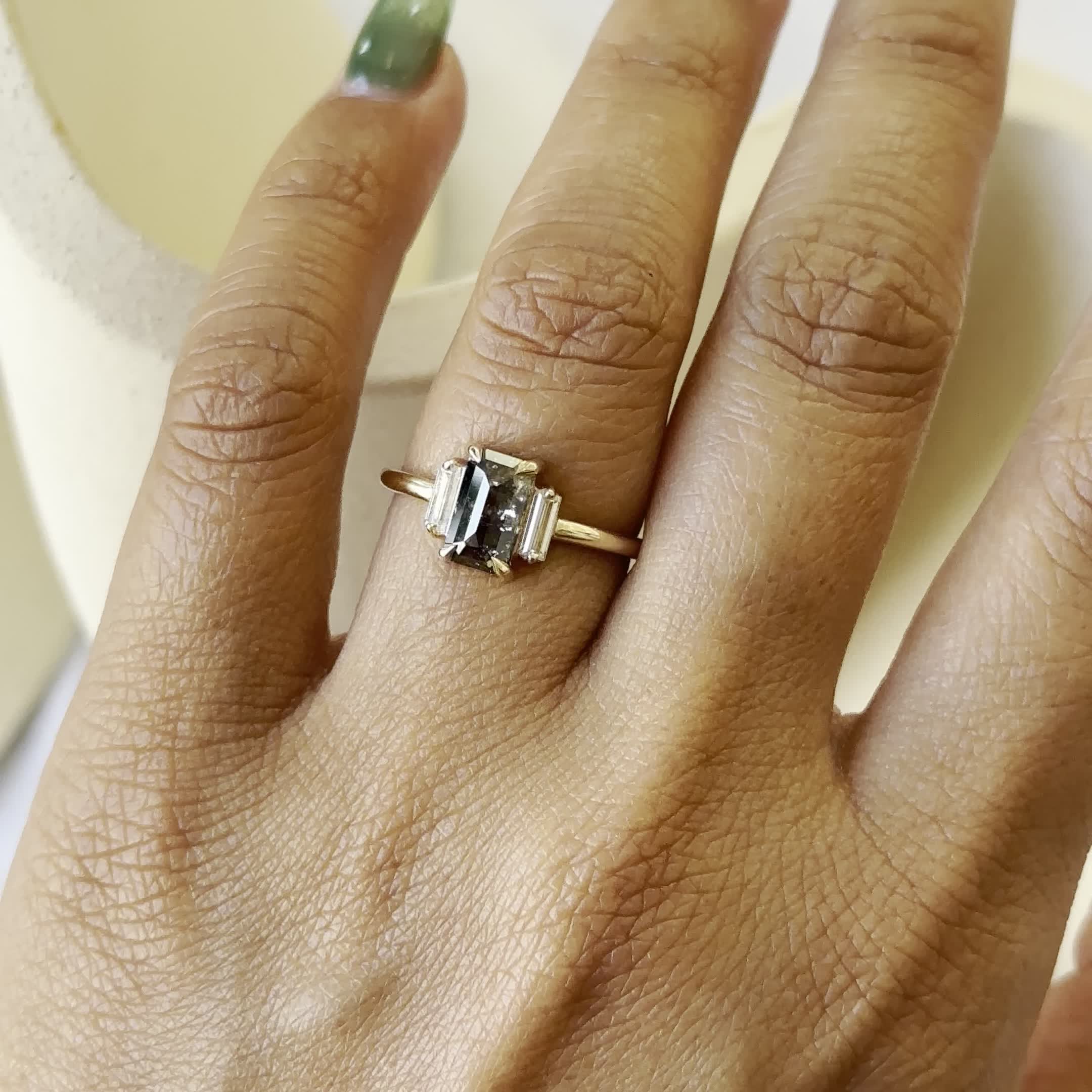 This may contain: a woman's hand with a ring on it and a green manicured nail