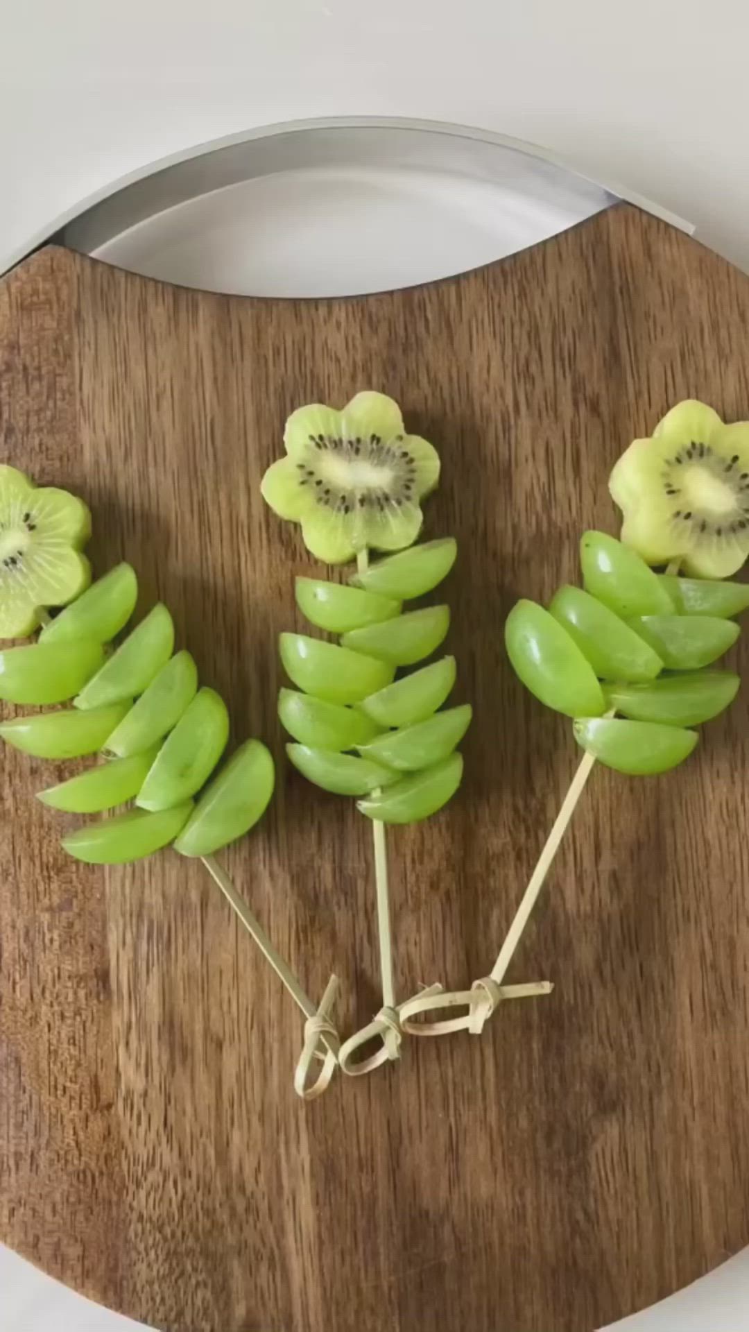 This may contain: a wooden cutting board topped with kiwi slices