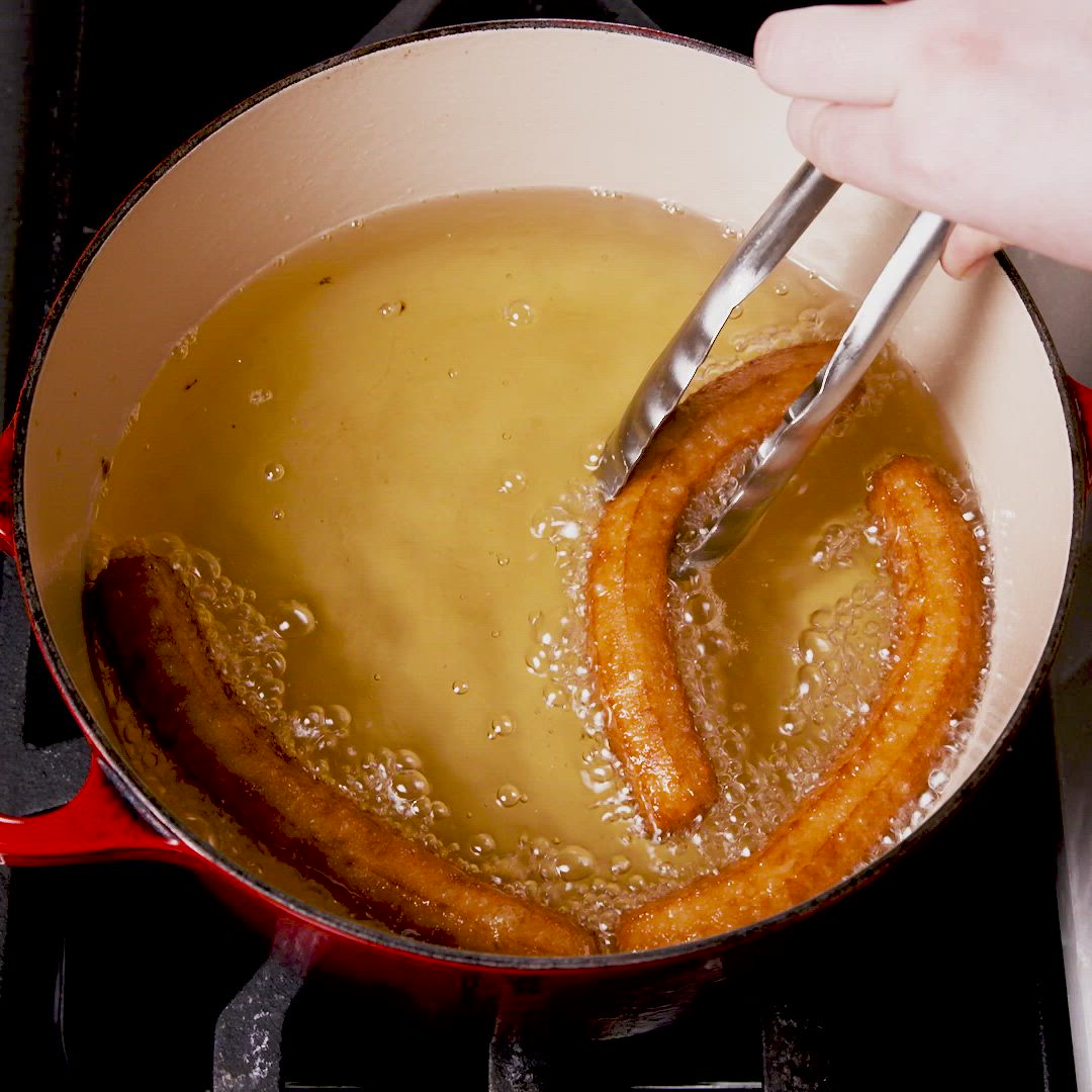 This may contain: a person is stirring some food in a pot on the stove with two tongs