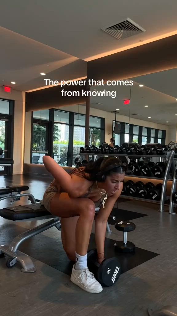 This may contain: a woman squatting on a bench in a gym with the words, the power that comes from known