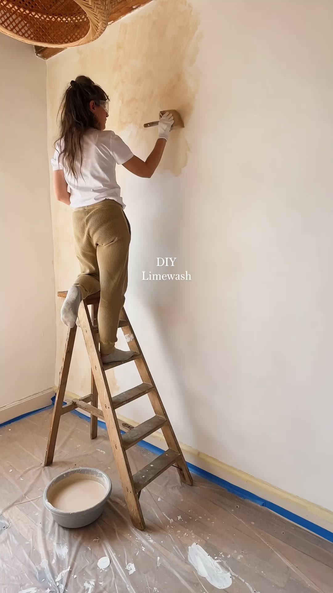 This may contain: a woman is painting the walls in her home