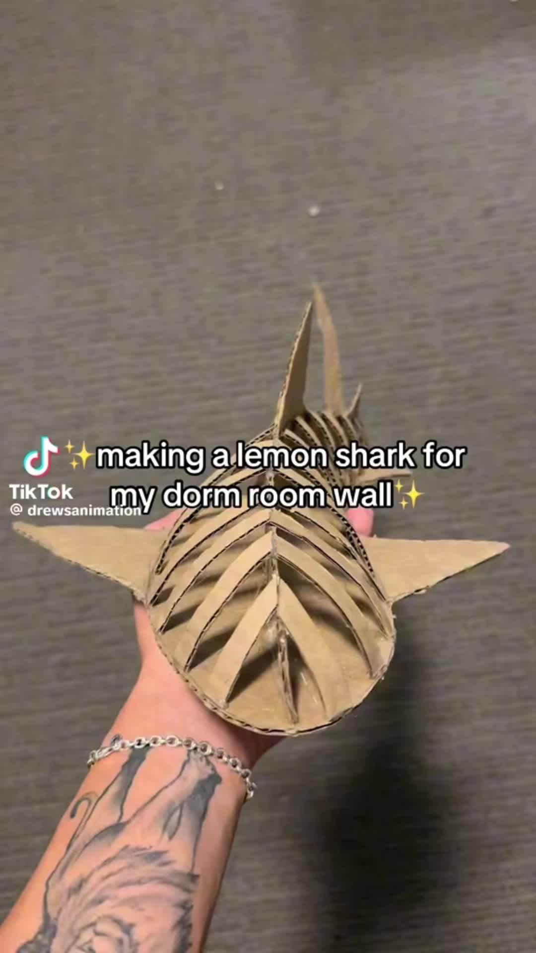 This may contain: someone is holding an origami star in their hand with the words making a lemon shark for my dorm room wall