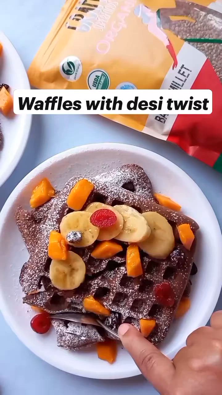 This may contain: waffles with desi twist chocolate and bananas on top are being eaten by someone