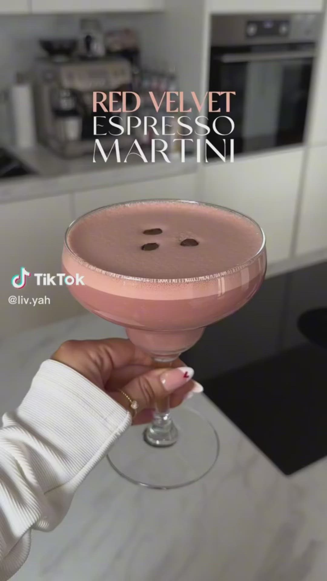 This may contain: a person holding a drink in their hand with the caption red velvet espresso martini