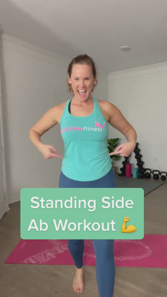 This may contain: a woman standing on a yoga mat with the words standing side ab workout below her