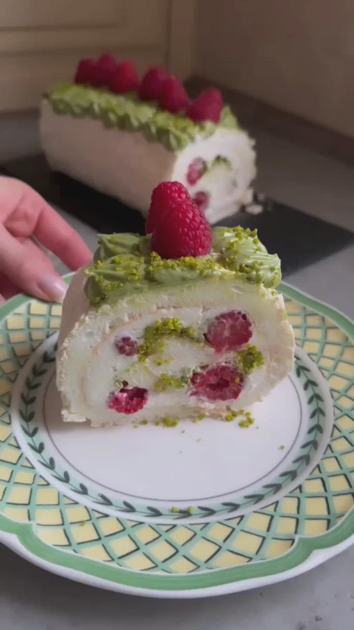 This may contain: two pieces of cake with raspberries on top and one piece cut in half