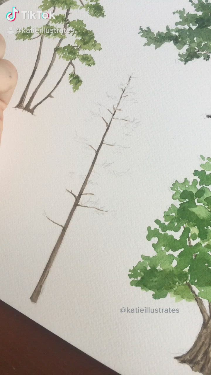 This may contain: someone is using scissors to paint trees on the paper with watercolors and ink