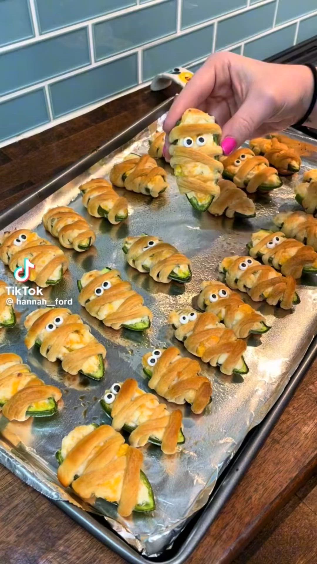 This may contain: there are many small sandwiches with eyes on the baking sheet, ready to go into the oven