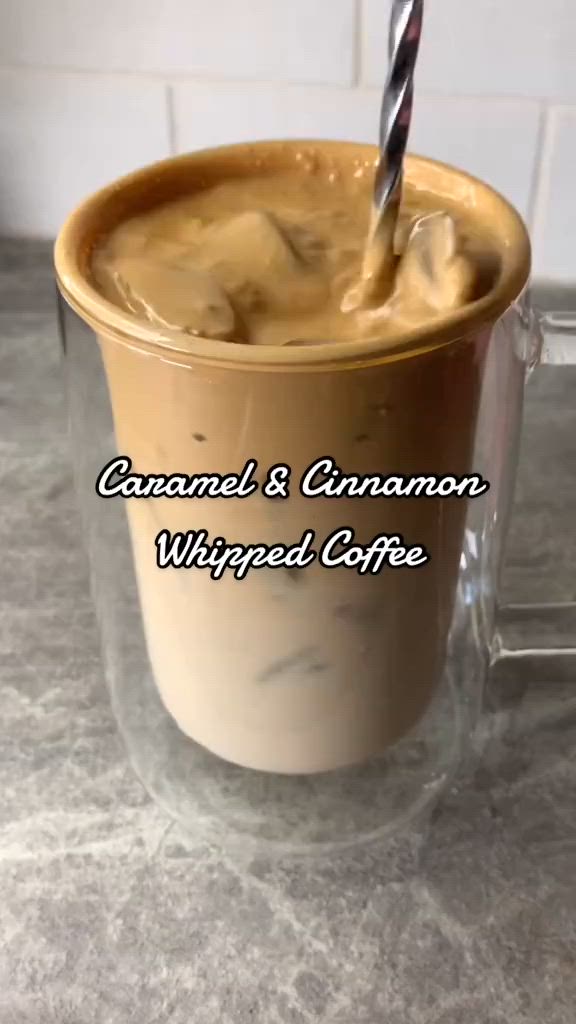 This may contain: a coffee cup with caramel and cinnamon whipped coffee in it