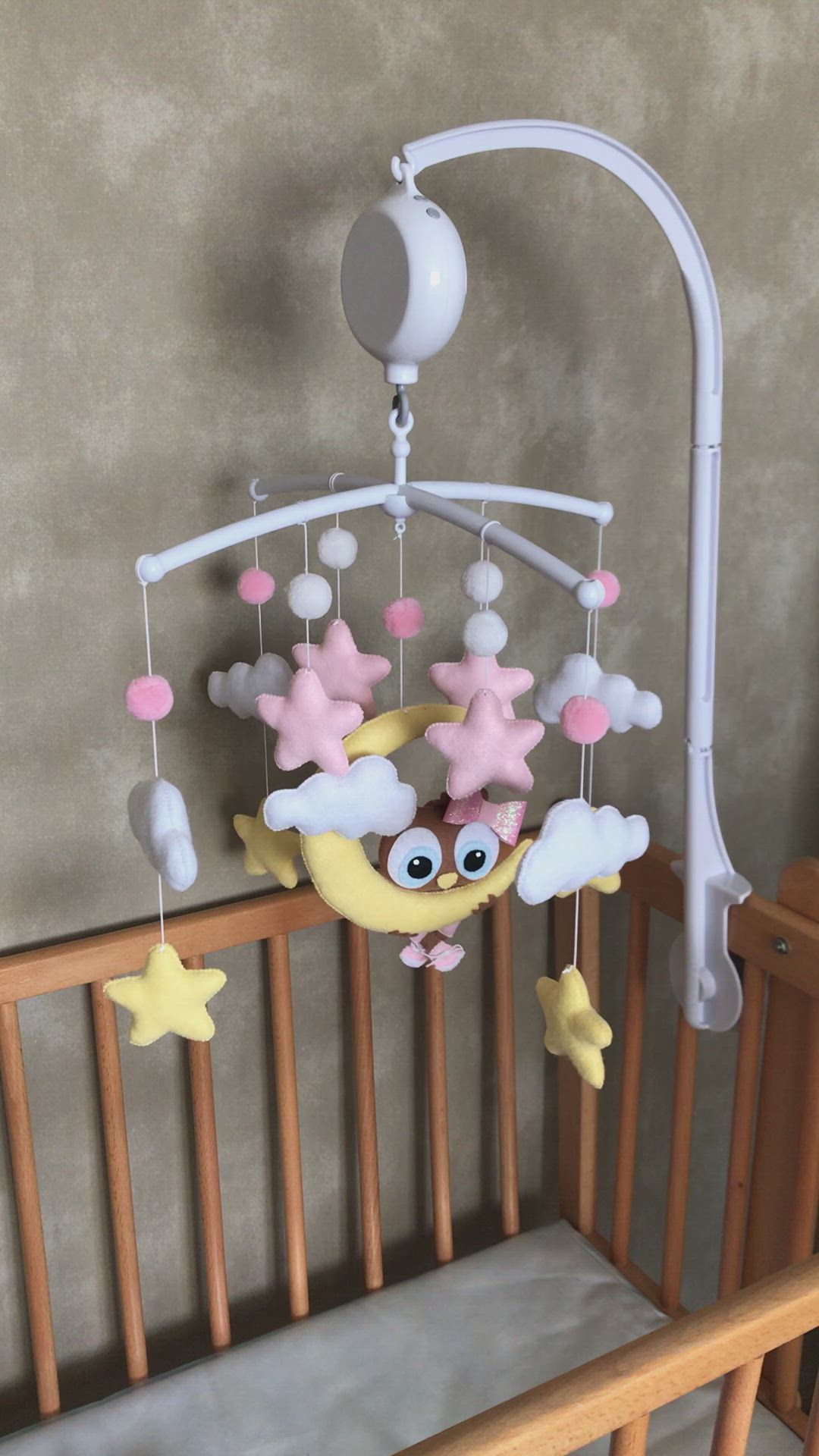 This may contain: a baby crib with a mobile hanging from it's side