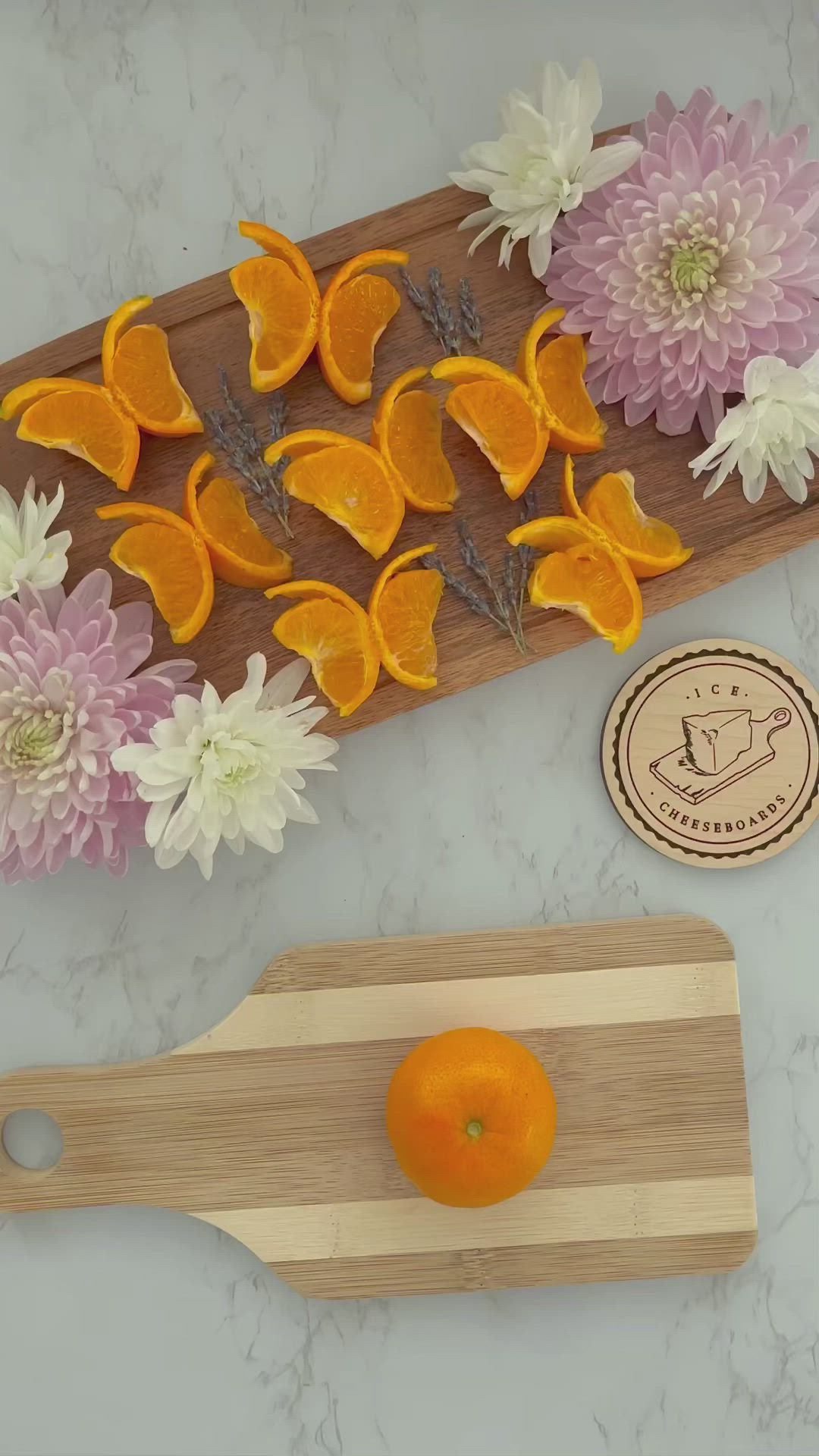 This may contain: orange slices and flowers on a cutting board