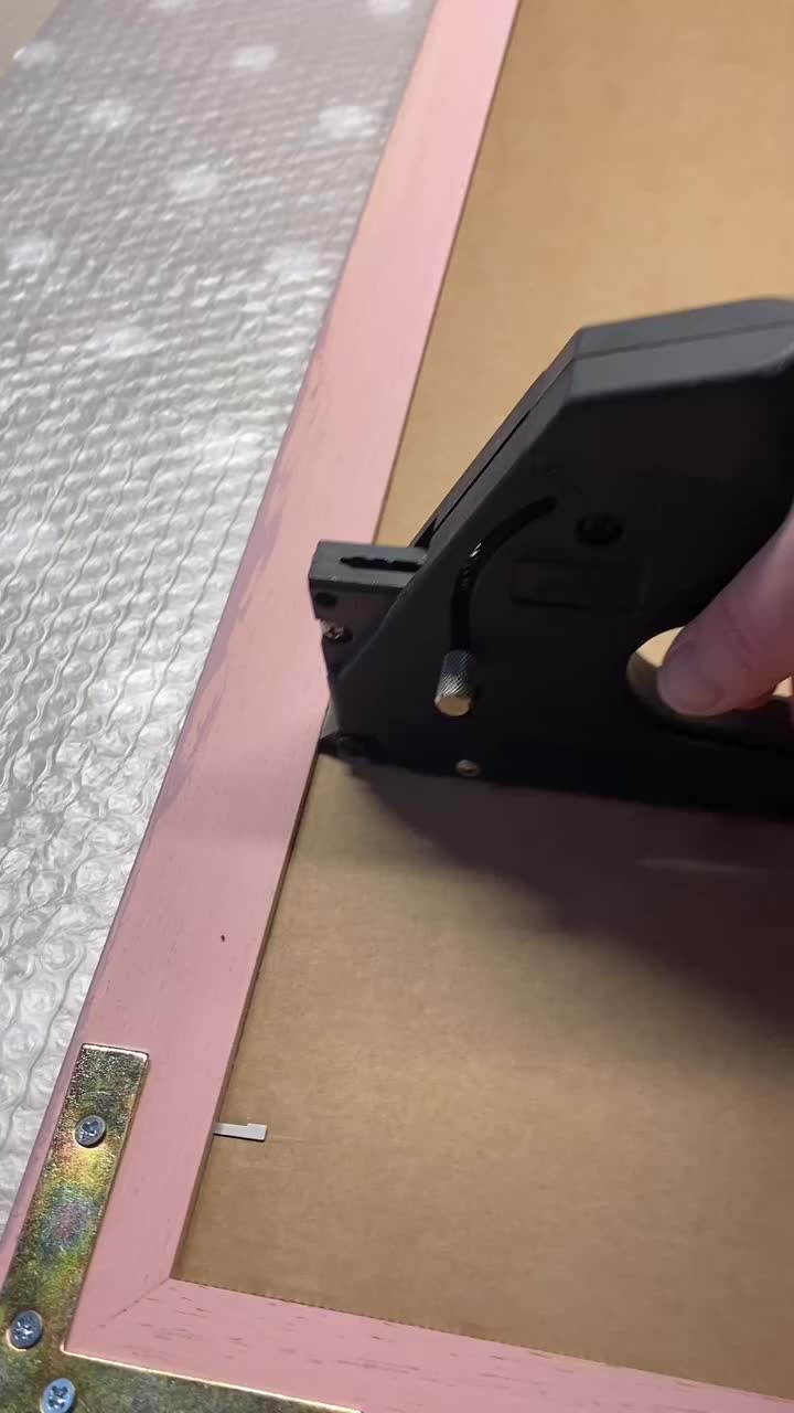 This may contain: someone is using a piece of tape to cut out the bottom part of a frame